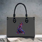 Gray handbag with a colorful embroidered design on a textured surface
