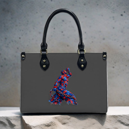 Gray handbag with a colorful embroidered design on a textured surface