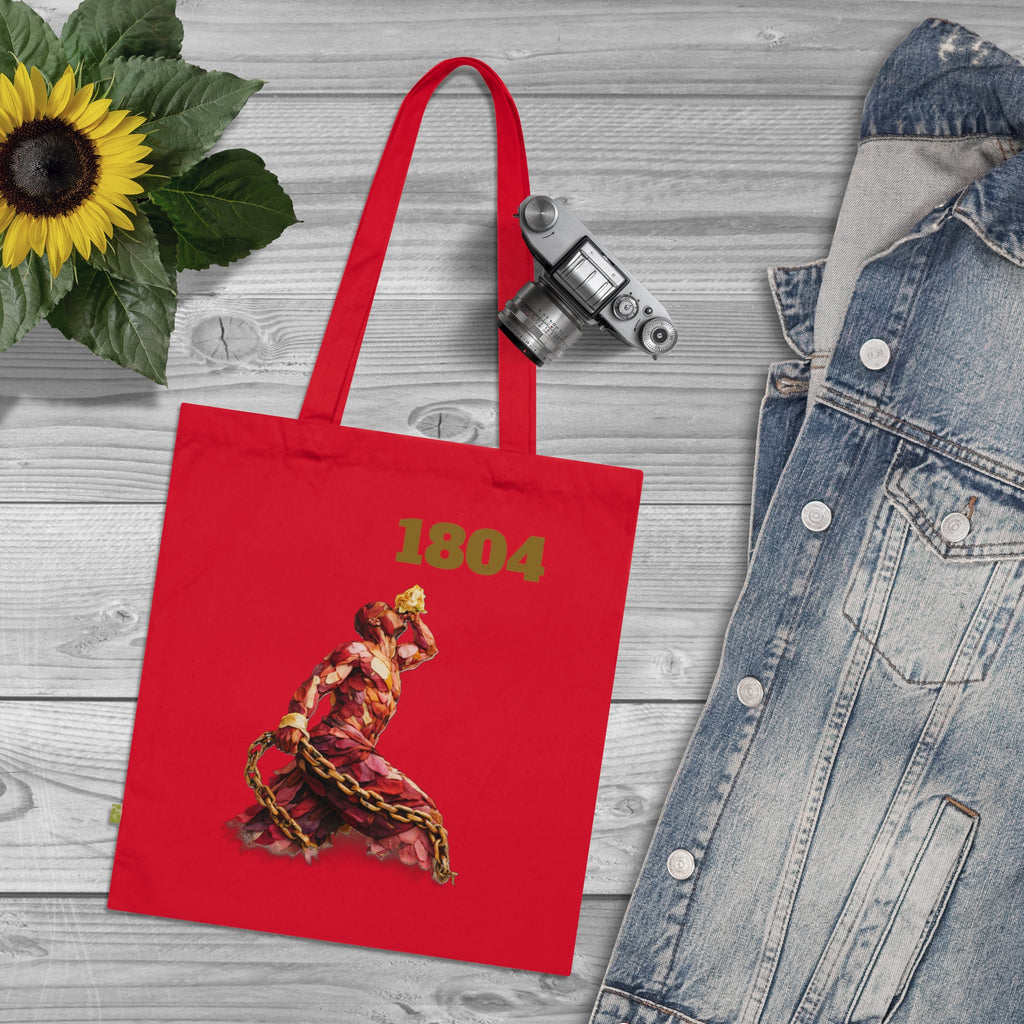 Red tote bag with '1804' design on a wooden surface with denim jacket and sunflower.