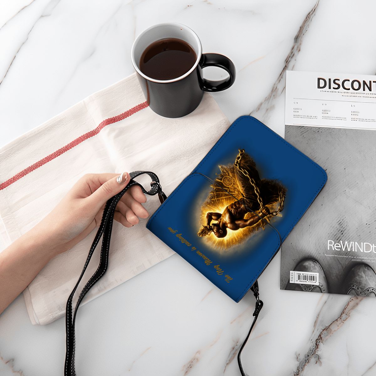 Blue pouch with butterfly design held by a hand on a marble surface with a cup of coffee and newspaper.